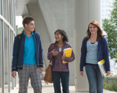 3 students walking outside on campus