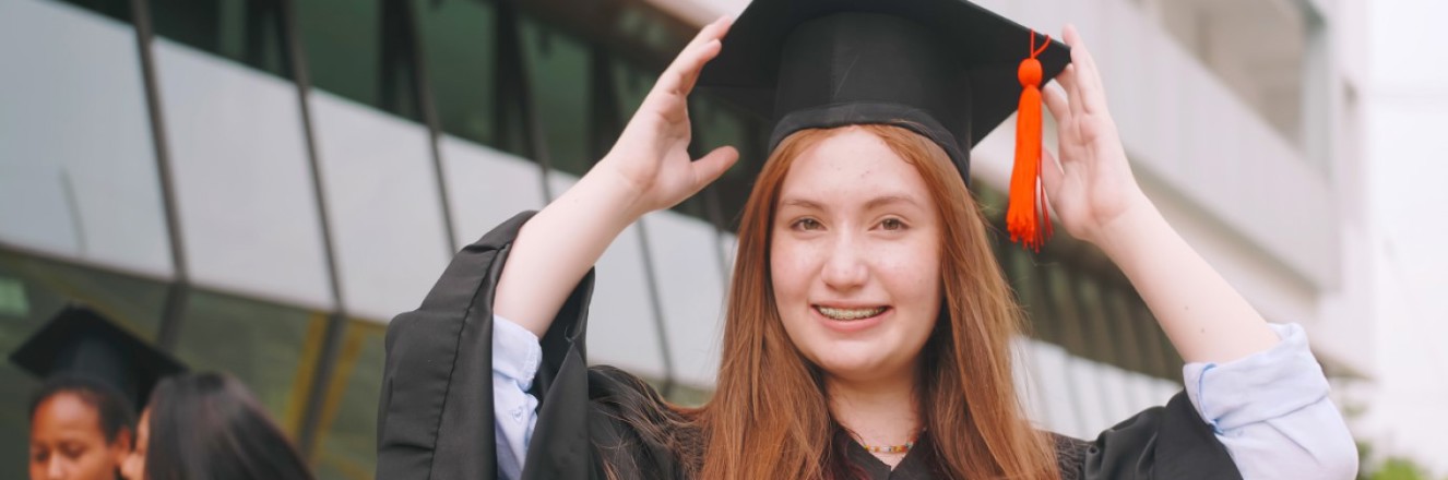 High school student posing for graduation photo in cap and gown. 