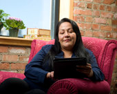 Person sitting in an armchair while looking at a laptop