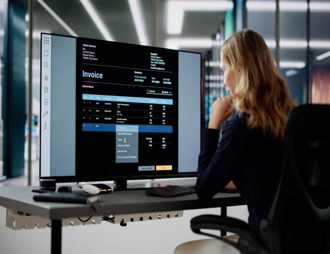 Person using computer software to manage invoices.