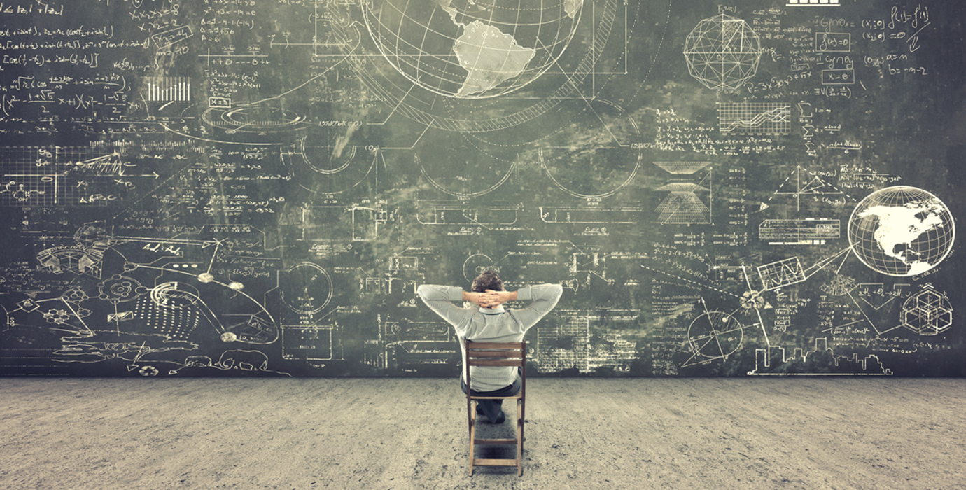 Person looking at a giant chalkboard filled with drawings and text
