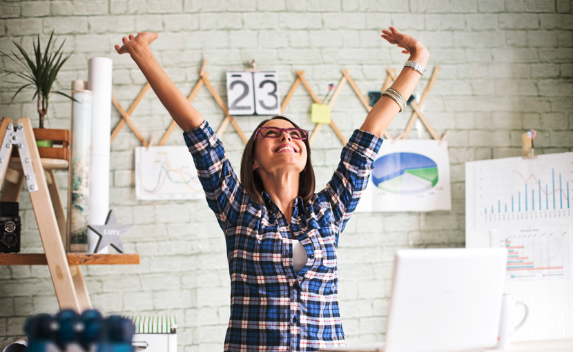 Person in an office throwing hands up in the air in excitement
