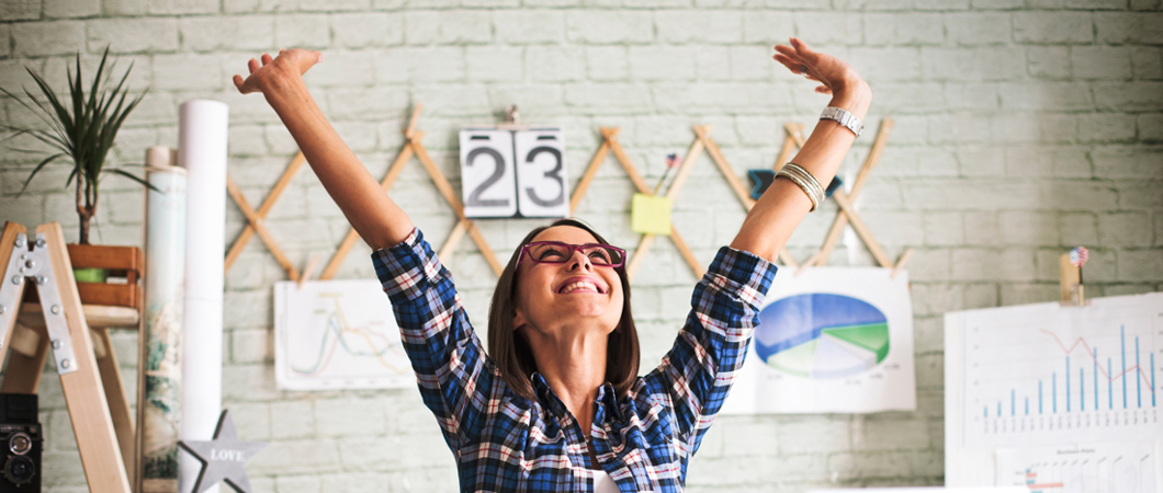 Person in an office  throwing hands up in the air in excitement