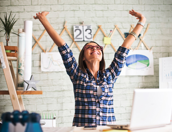 Person in an office  throwing hands up in the air in excitement