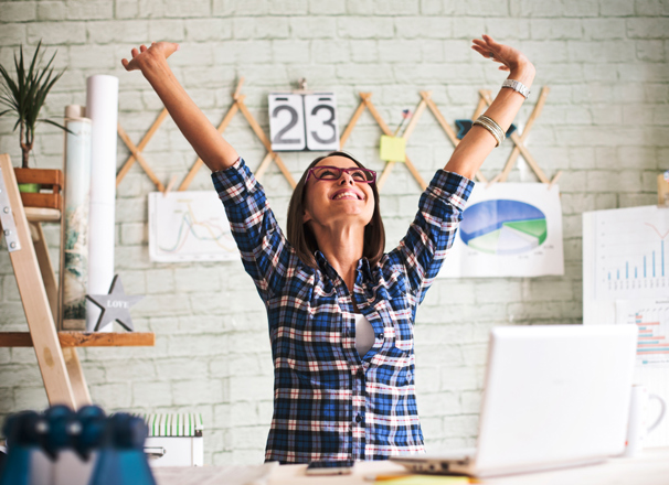 Person in an office  throwing hands up in the air in excitement