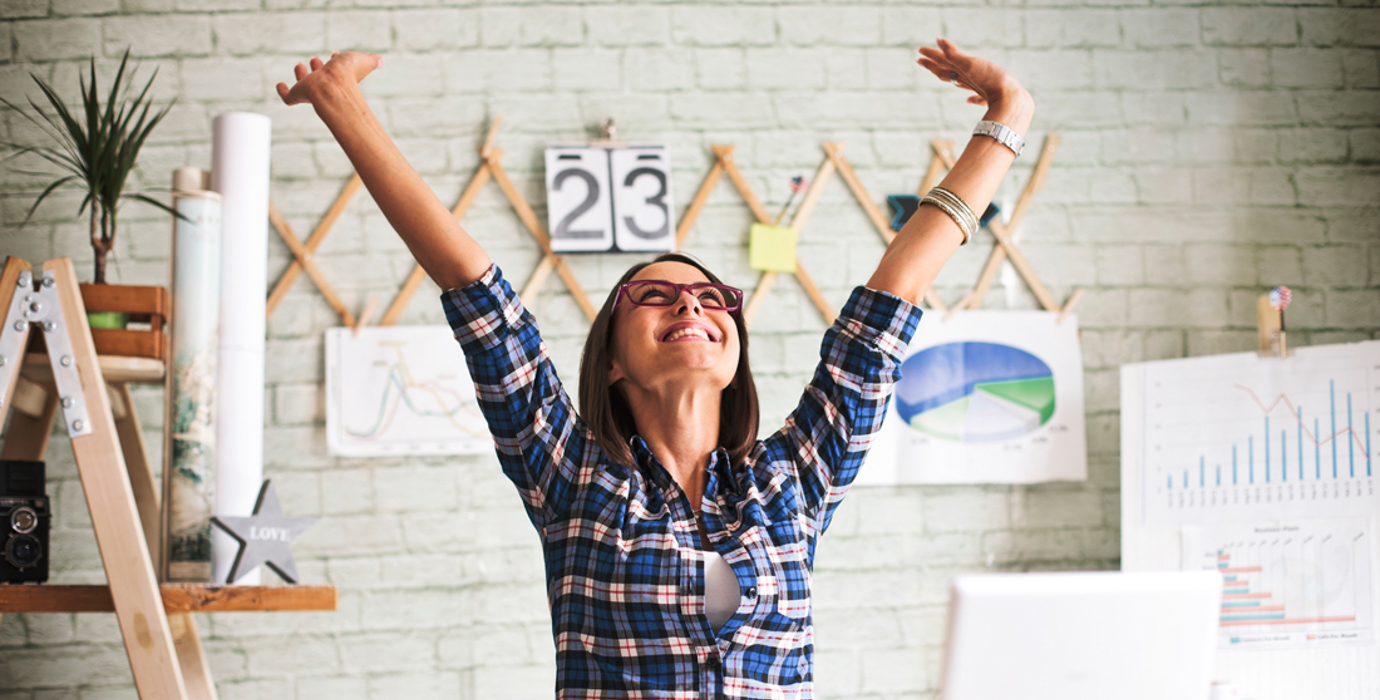 Person in an office  throwing hands up in the air in excitement