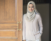 Person smiling while leaning against an open door