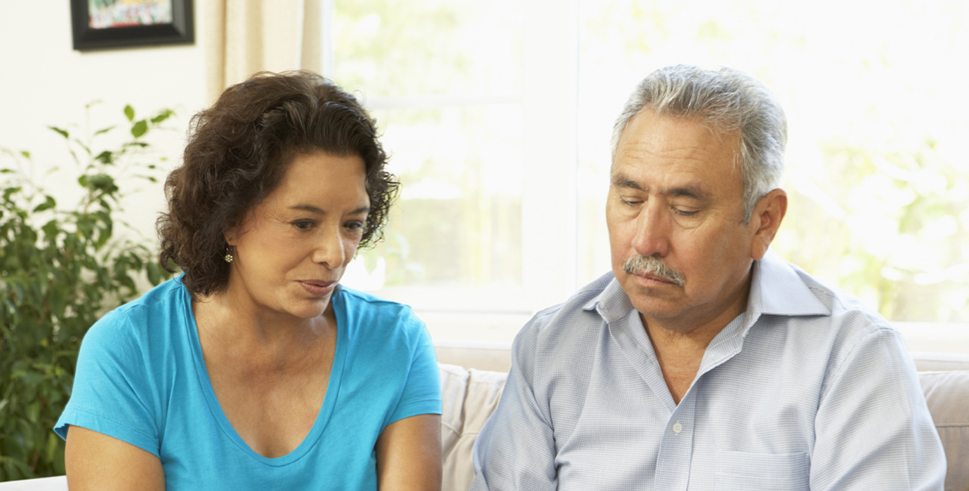 Couple looking at paperwork on the couch 