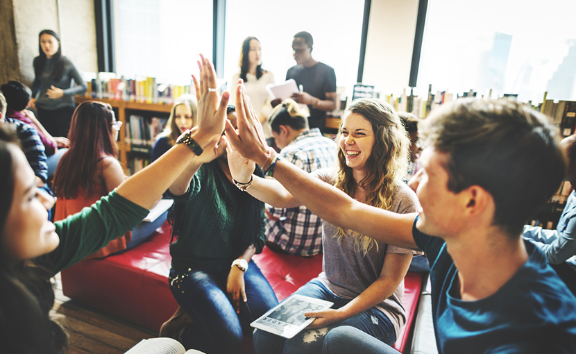 Students high fiving in a library