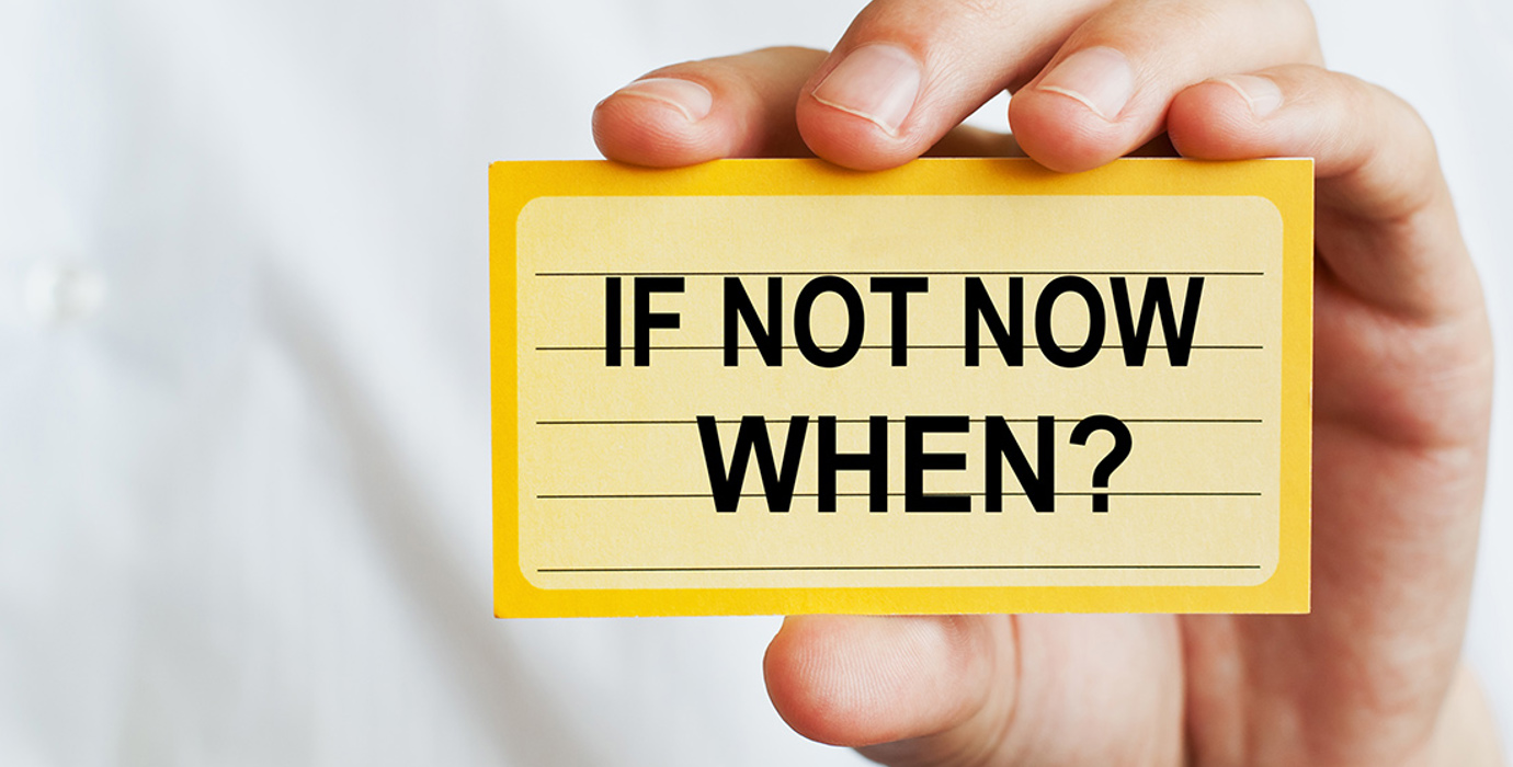 Hand holding up an index card with the message, "If not now, when?"