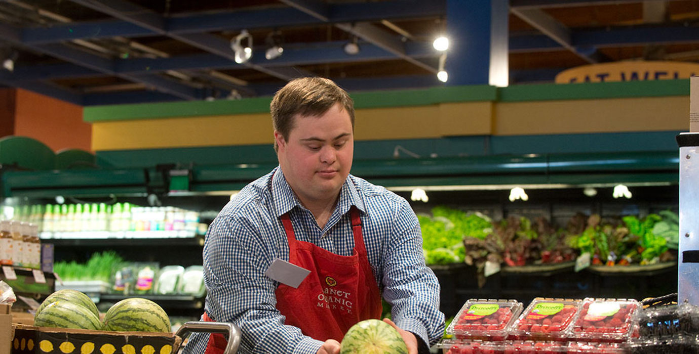 Employee working a the produce area of a grocery store