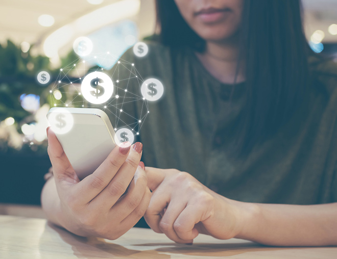 Person holding a smartphone with dollar sign graphics overlaid