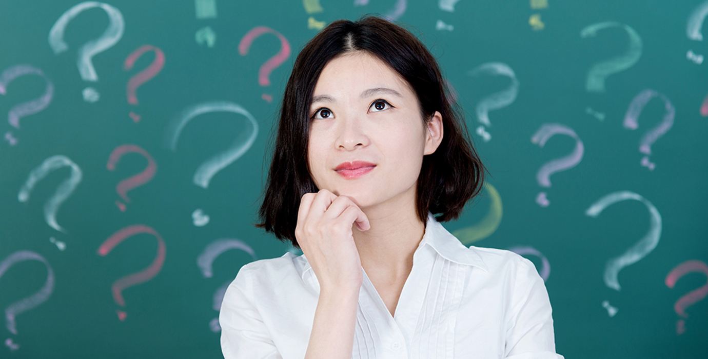 Person looking up with chin in hand in front of a background of question marks