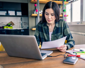 Person working at home with laptop and paper