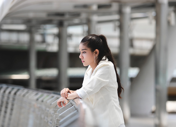 Person thinking and leaning against a railing