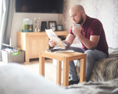 Person reviewing paperwork while sitting in the living room