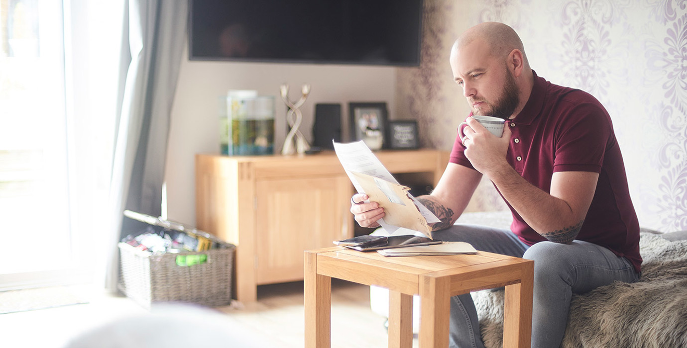 Person reviewing paperwork while sitting in the living room