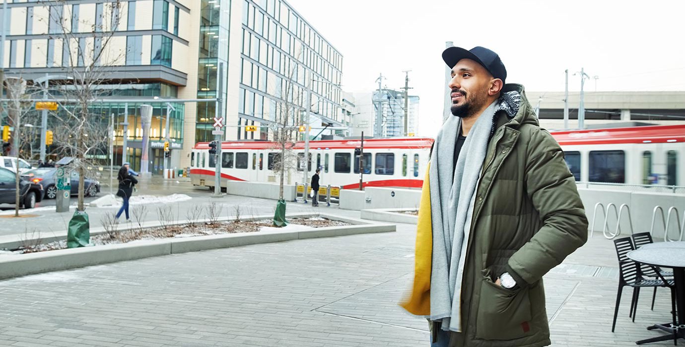Person walking downtown wearing a winter coat and scarf