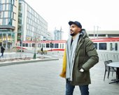 Person walking downtown wearing a winter coat and scarf
