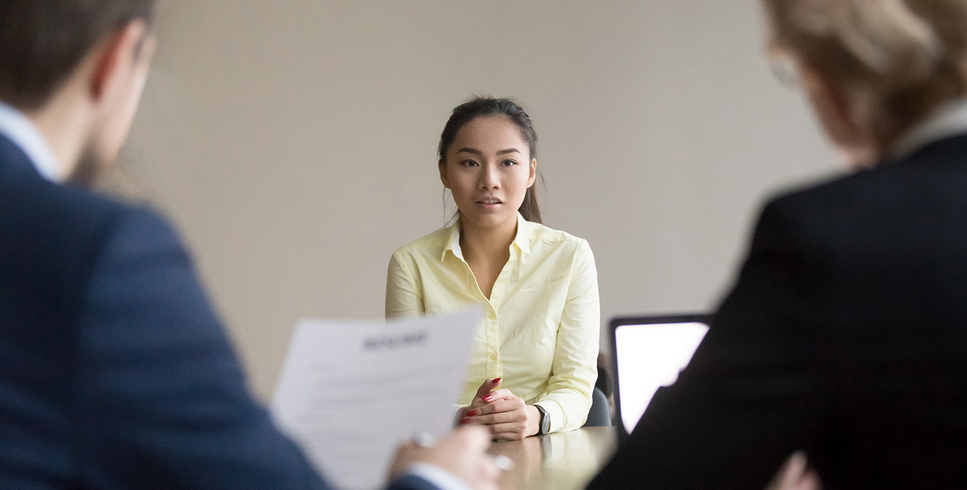 Job seeker facing 2 interviewers in a meeting room