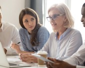 Mature worker in a meeting with coworkers