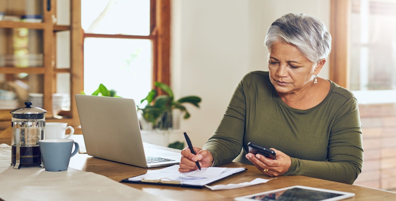 Person taking notes at a kitchen counter