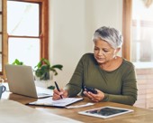 Person taking notes at a kitchen counter