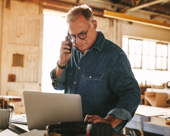Carpenter on the phone in a workshop