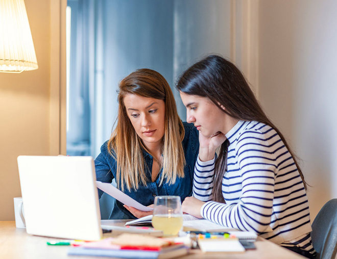 Mother helping her daughter with homework.