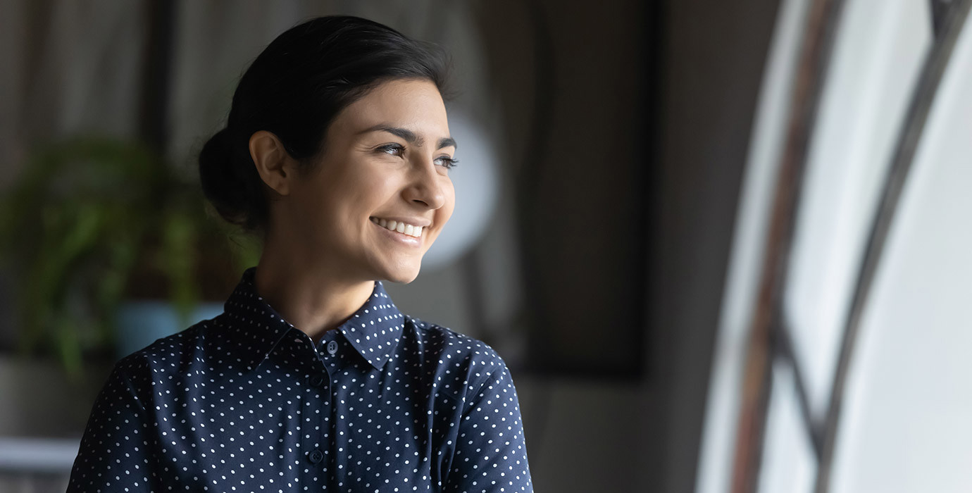 Woman smiling and looking out of a window.
