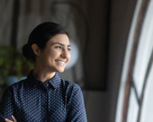 Woman smiling and looking out of a window.