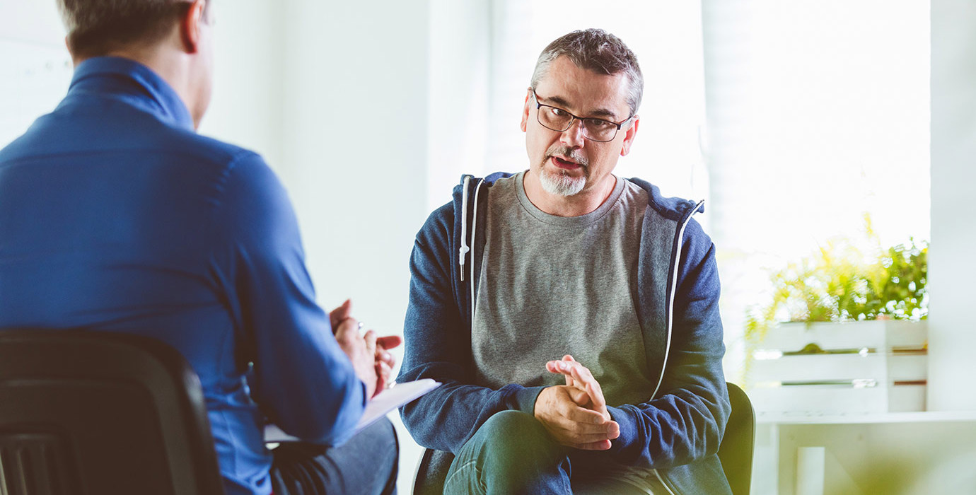 A mature person converses with a therapist.