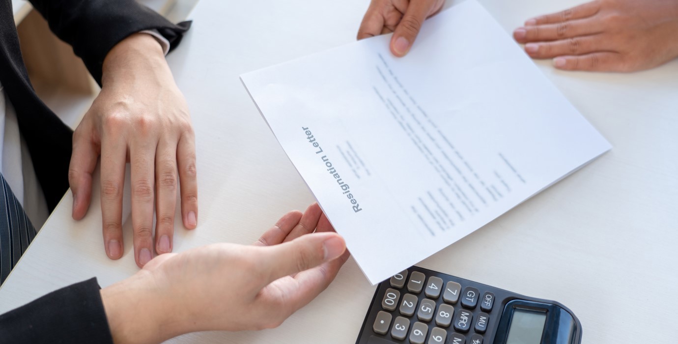 Employee handing their employer a resignation letter.
