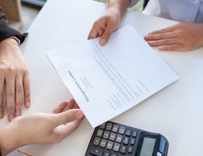 Employee handing their employer a resignation letter.