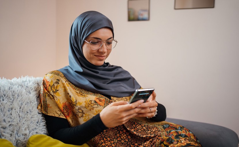 Person using smartphone while sitting on couch.
