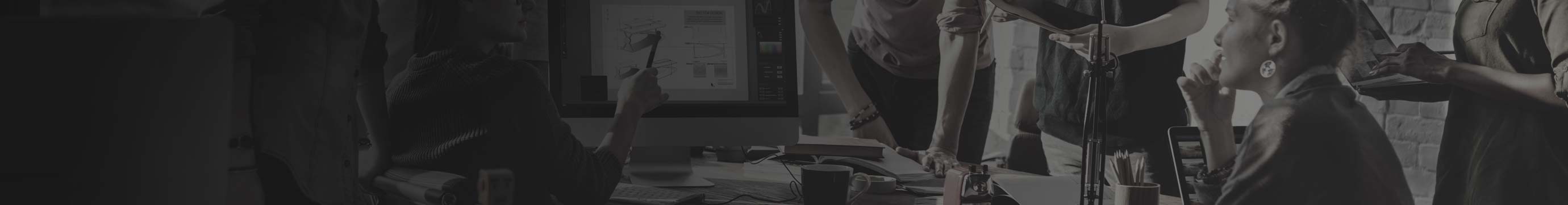 Black and white background image with colleague standing at desk