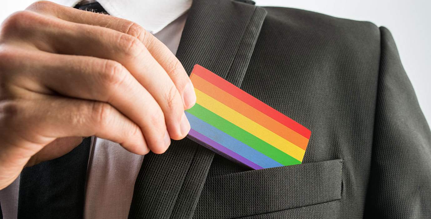 LGBT pride flag business card being pulled out of suit pocket