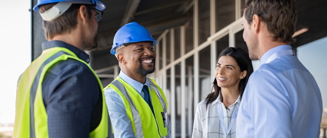 Workers shaking hands on a construction site. 