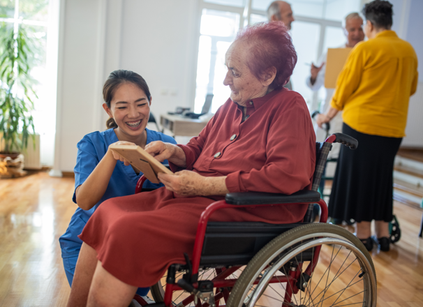 Homecare worker helping person in wheelchair.