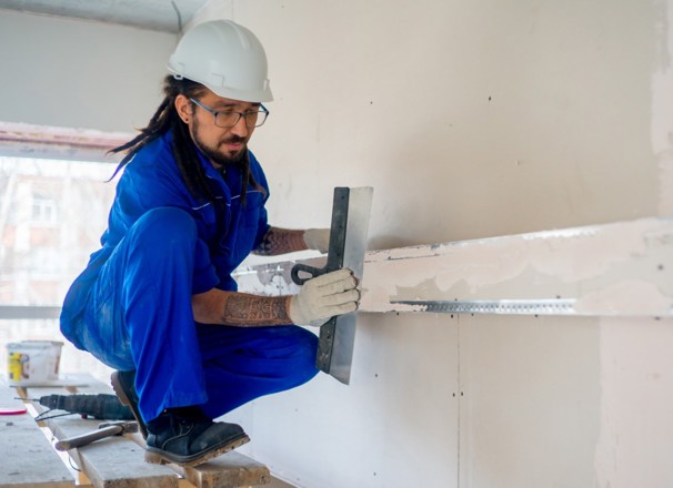 Construction worker finishing a wall.