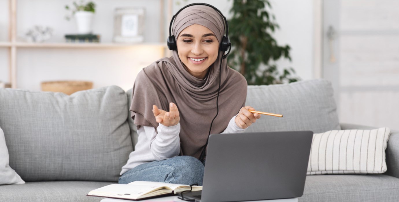 Person interviewing someone on laptop while sitting on couch.