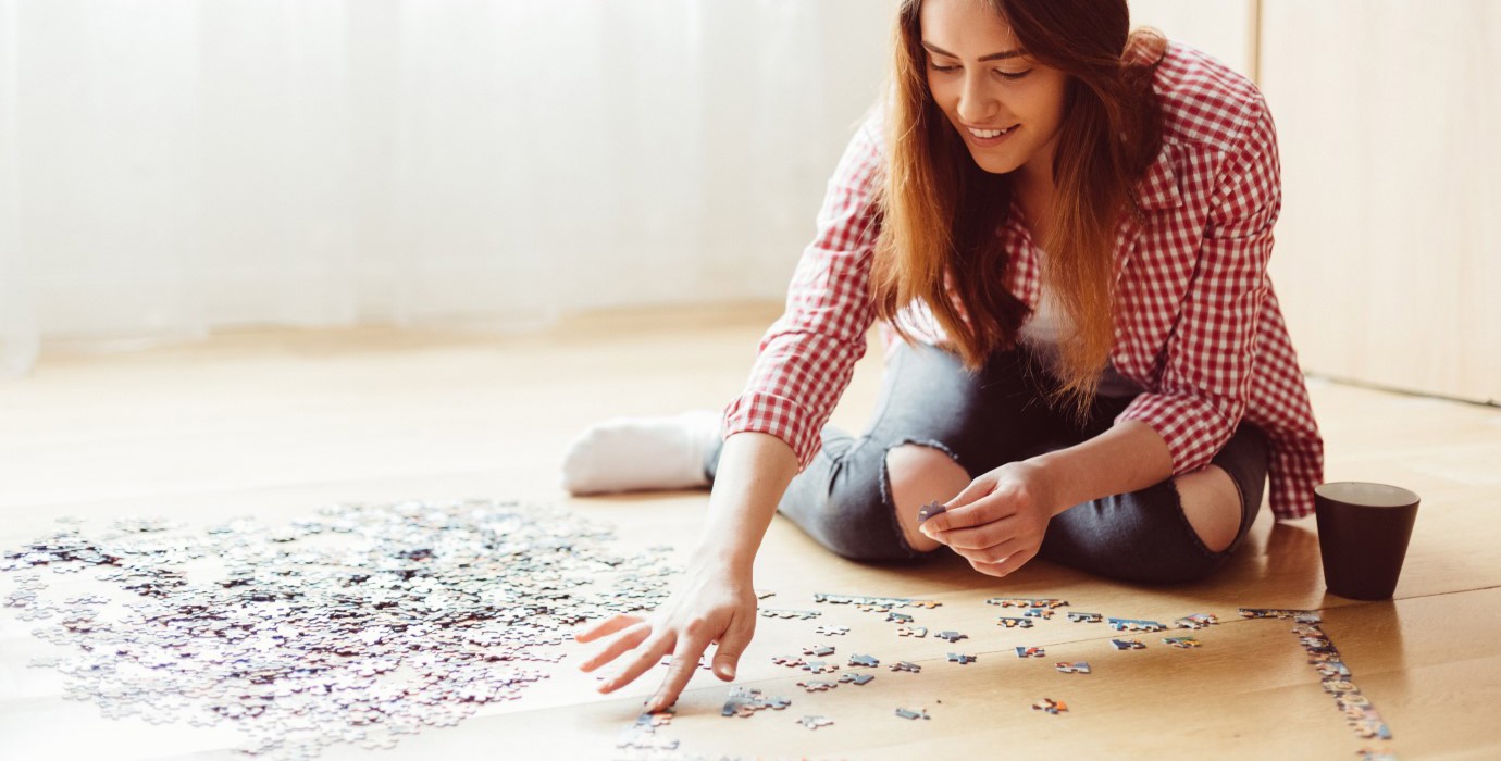 Person doing a puzzle on the floor.