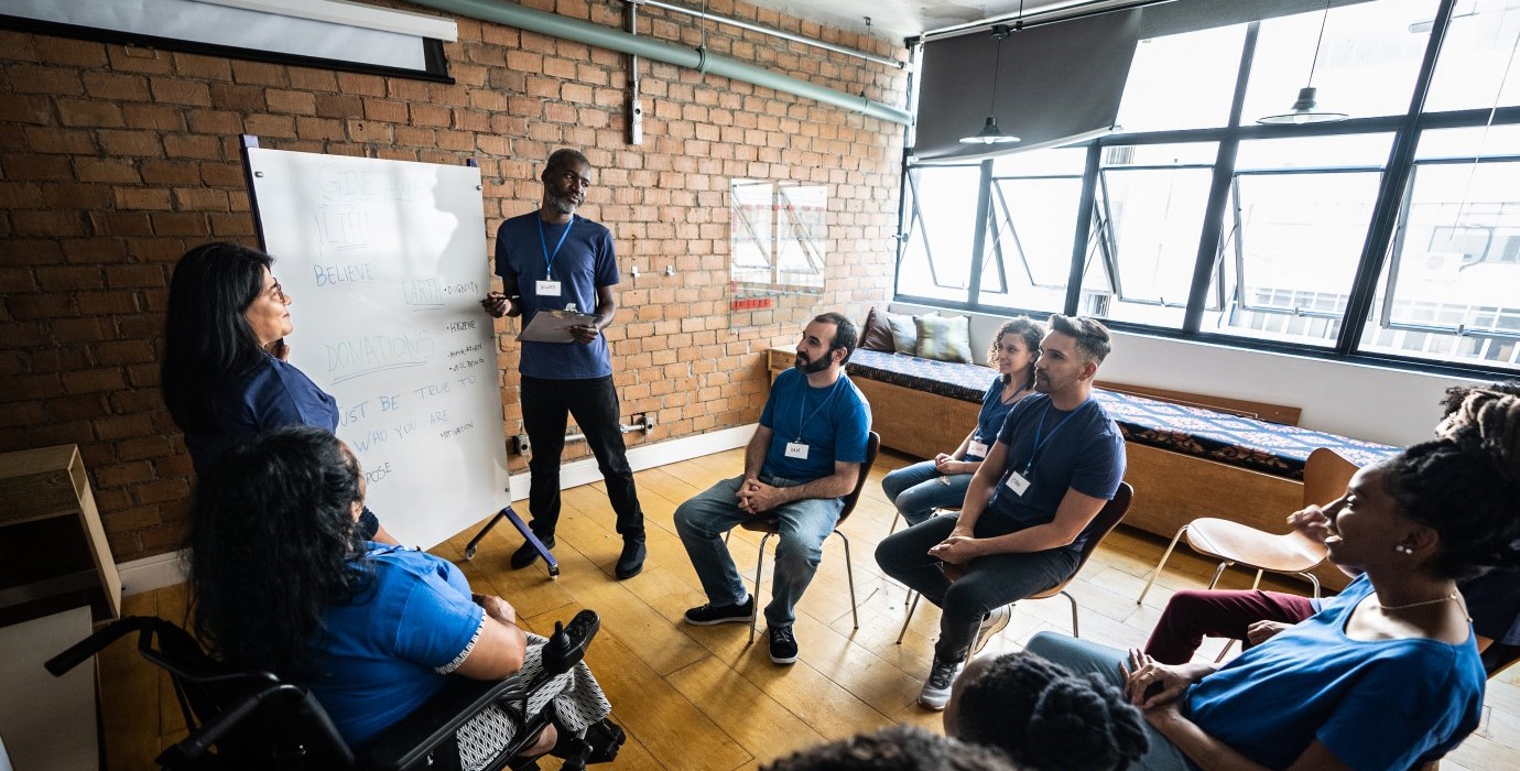 Person teaching a group of mature students.
