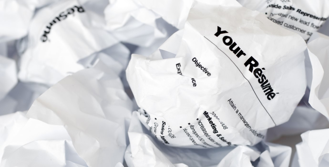 A crumpled resumé in a pile of rejected resumés.