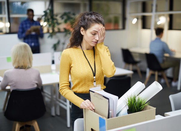 Person packing personal items in box after being fired from office job. 