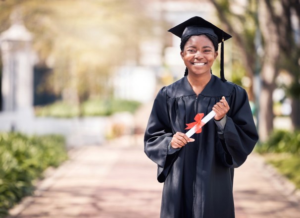 Student posing in cap and gown on high school graduation day. 