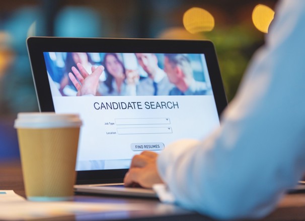 Employer using software on laptop to find candidates for job. 